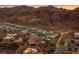 Aerial view of a desert neighborhood surrounded by rugged mountains and a colorful sunset at 503 Aaron Way, Boulder City, NV 89005