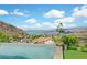 Infinity pool with views of mountains, lake, neighborhood, flamingo lawn ornament and lush landscaping at 503 Aaron Way, Boulder City, NV 89005
