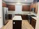 Spacious kitchen featuring stainless steel appliances, granite countertops, island, and rich wood cabinets at 5179 Silica Chalk Ave, Las Vegas, NV 89115