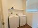 A bright laundry room featuring modern, white washer and dryer appliances with a window at 5179 Silica Chalk Ave, Las Vegas, NV 89115