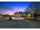Gorgeous backyard featuring a sparkling swimming pool with rock feature and partially covered patio at dusk at 5690 N Park St, Las Vegas, NV 89149