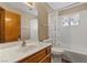 Bathroom with white tiled shower/tub and single sink vanity at 5690 N Park St, Las Vegas, NV 89149