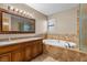 Bright bathroom featuring double sinks, a luxurious soaking tub, and glass enclosed shower at 5690 N Park St, Las Vegas, NV 89149