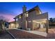 Charming home with a covered patio, string lights, and a low maintenance desert landscape at dusk at 5690 N Park St, Las Vegas, NV 89149