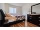 Bedroom with a bed, a dresser and a view of the natural wood flooring at 5771 Ritter Ln, Las Vegas, NV 89118