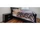 Bedroom with a bed, a nightstand and a view of the natural wood flooring at 5771 Ritter Ln, Las Vegas, NV 89118
