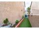 Clean side yard with artificial grass, brick planters, and manicured landscaping at 5771 Ritter Ln, Las Vegas, NV 89118
