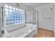 Bright bathroom featuring a tub, separate shower, and unique glass block window for natural light at 6405 Break Point Ave, Las Vegas, NV 89130