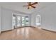 Bright bedroom with tile floors, ceiling fan, and double doors leading to the backyard and attached bath at 6405 Break Point Ave, Las Vegas, NV 89130