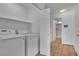 Functional laundry room equipped with a washer, dryer, and storage shelf for convenience at 6405 Break Point Ave, Las Vegas, NV 89130