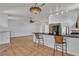 Bright living space featuring tile floors, modern lighting, and a breakfast bar with seating at 6405 Break Point Ave, Las Vegas, NV 89130