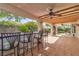 Relaxing outdoor bar area with tile flooring, ceiling fans, and seating for entertaining at 6405 Break Point Ave, Las Vegas, NV 89130
