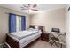 Cozy bedroom features a ceiling fan and a comfortable bed near a window with blue curtains at 6476 Little Harbor Ct, Las Vegas, NV 89141