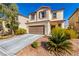 Charming two-story home featuring a neutral stucco exterior, complemented by a well-maintained front yard and two-car garage at 6476 Little Harbor Ct, Las Vegas, NV 89141