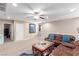 Cozy living room area with leather couches, a ceiling fan, and access to other rooms in the home at 6476 Little Harbor Ct, Las Vegas, NV 89141
