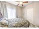 Cozy bedroom with a large window, soft curtains, and a comfortable bed covered with an elegant patterned duvet at 6484 Mount Eden Ave, Las Vegas, NV 89139