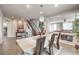 Elegant dining room with modern chandelier, stairs, and living room view at 6484 Mount Eden Ave, Las Vegas, NV 89139