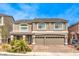 Two-story home with a beige facade, a two-car garage, and a brick driveway at 6484 Mount Eden Ave, Las Vegas, NV 89139