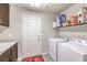 Functional laundry room with washer, dryer, storage shelving and a utility sink for added convenience at 6484 Mount Eden Ave, Las Vegas, NV 89139