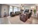 Spacious living room with leather furniture, fireplace, and ceiling fan at 6484 Mount Eden Ave, Las Vegas, NV 89139