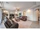 Comfortable living room with a ceiling fan, leather furniture, and ample lighting at 6484 Mount Eden Ave, Las Vegas, NV 89139