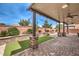 Beautiful backyard patio featuring stone pillars, manicured lawn, and a soothing water fountain at 6484 Mount Eden Ave, Las Vegas, NV 89139