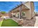 Large outdoor patio featuring stone pillars, a covered seating area, and a manicured lawn at 6484 Mount Eden Ave, Las Vegas, NV 89139