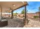 Expansive covered patio featuring stone pillars, lush landscaping, a water fountain, and ample seating at 6484 Mount Eden Ave, Las Vegas, NV 89139