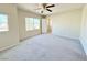 Spacious bedroom with neutral carpet, ceiling fan, and large windows for ample natural light at 6625 Gossamer Fog Ave, Las Vegas, NV 89139