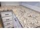 Close up of granite countertop with white cabinets and black hardware at 6649 W Tropicana Ave # 101, Las Vegas, NV 89103