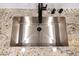 Close up of a stainless kitchen sink with black faucet set in granite countertops at 6649 W Tropicana Ave # 101, Las Vegas, NV 89103