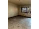 Bedroom featuring a window with security bars, stained walls, and tile flooring at 709 G St, Las Vegas, NV 89106