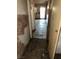 Hallway leading to a bright doorway with damaged walls and flooring needing repair at 709 G St, Las Vegas, NV 89106