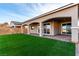 Serene backyard with a covered patio and well-maintained artificial grass, perfect for relaxation at 76 Tatahatso Point St, Henderson, NV 89011