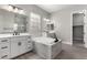 This bright bathroom features dual vanities, a soaking tub with marble surround, and modern fixtures at 76 Tatahatso Point St, Henderson, NV 89011