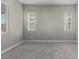 Relaxing bedroom with neutral walls, carpet, and two bright windows for light and comfort at 76 Tatahatso Point St, Henderson, NV 89011