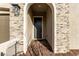 Charming home front door entrance featuring a stone facade and brick walkway at 76 Tatahatso Point St, Henderson, NV 89011