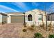 Charming single-story home with a brick driveway, two-car garage, stone accents, and arched entryway at 76 Tatahatso Point St, Henderson, NV 89011