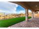 Picturesque backyard featuring a covered patio with column supports and an easy-care lawn space at 76 Tatahatso Point St, Henderson, NV 89011