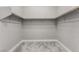 The carpeted walk-in closet features built in shelving and ample room for storage at 76 Tatahatso Point St, Henderson, NV 89011