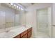 Bright bathroom with dual sinks, vanity lighting and combined tub and shower at 7641 Jacaranda Bay St, Las Vegas, NV 89139