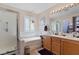 Bright bathroom featuring double sinks, a bathtub and shower combo with tiled walls and chrome fixtures at 8125 Boxberry Ave, Las Vegas, NV 89131