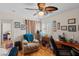 Cozy bedroom features a ceiling fan, hardwood floors, and lots of pictures hung on the wall at 8125 Boxberry Ave, Las Vegas, NV 89131