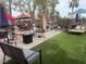 Backyard features patio with seating, artificial turf, and mature landscaping at 8154 Flanders Terrace Dr, Las Vegas, NV 89123