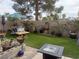 Backyard with artificial turf, patio furniture, mature landscaping and a fountain at 8154 Flanders Terrace Dr, Las Vegas, NV 89123