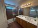 Bathroom featuring a glass shower, double sinks, and an expansive vanity mirror at 8154 Flanders Terrace Dr, Las Vegas, NV 89123