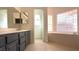 Bathroom featuring a dual sink vanity, soaking tub and tile flooring at 8216 Gillette St, Las Vegas, NV 89117