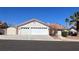 Beige home with a red tile roof, mature landscaping, and a three car garage at 8216 Gillette St, Las Vegas, NV 89117