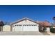 Beige home with a red tile roof and a three car garage with white doors at 8216 Gillette St, Las Vegas, NV 89117