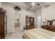 Main bedroom features plush carpet, ceiling fan, and glimpses into the attached main bathroom at 8266 Lincoln Valley St, Las Vegas, NV 89123